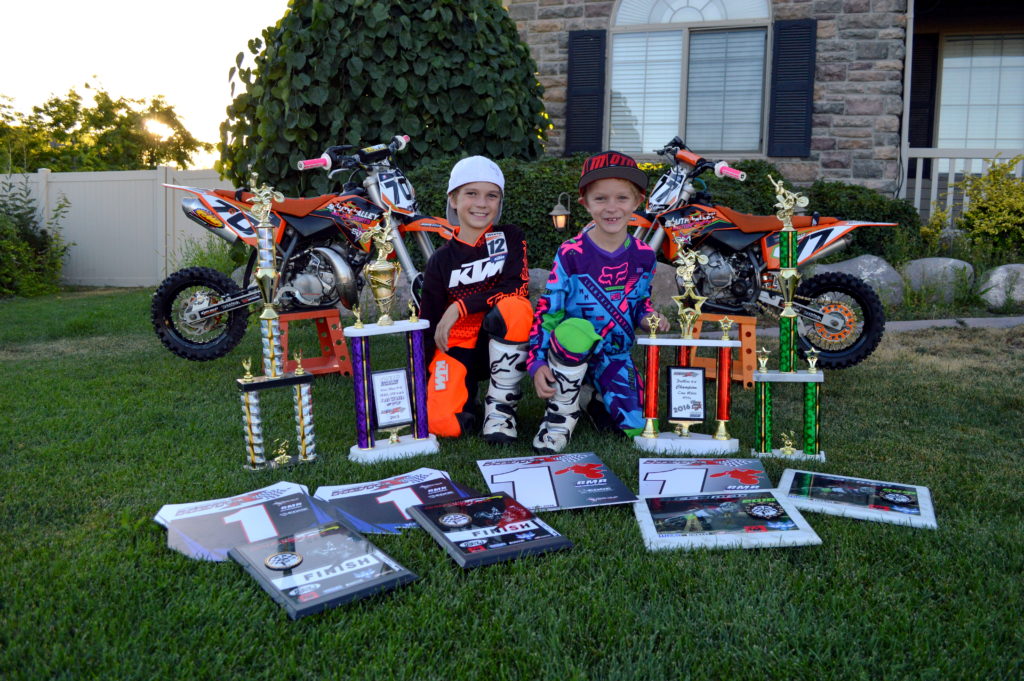 Jett and Cruz White surrounded by motocross racing awards. Photo courtesy of the White family