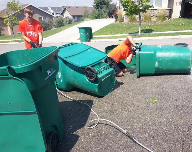 Skyridge Football cleans garbage cans to raise money for Shelbie. Photo courtesy of Greg Adamson