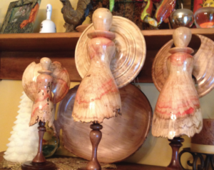 A collection of wooden angels and bowls crafted by Joe Ford.