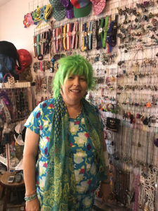 Rebekka Smith in front of her organized jewelry wall.  On this day she was looking for frog themed items.